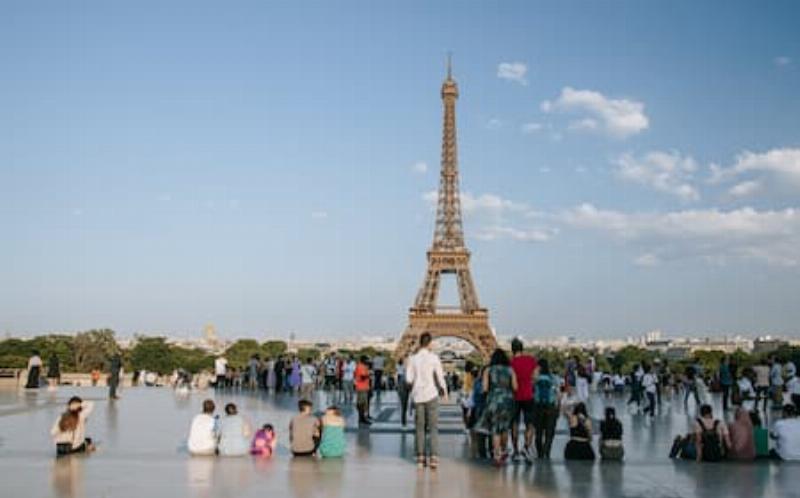 Une vue panoramique de Notre-Dame de Paris depuis un bus touristique à impériale, avec la Seine et des ponts historiques en contrebas.